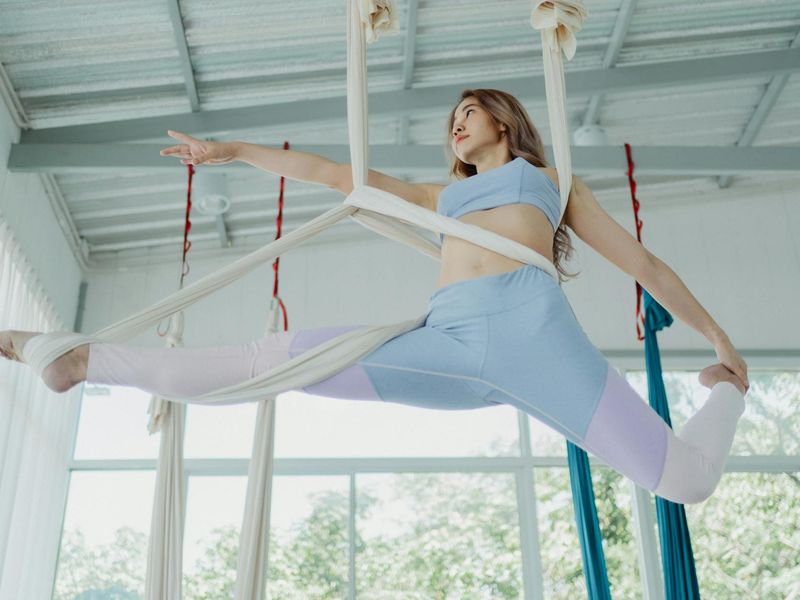 Woman performing a sequence of yoga movements in a bright, clean space.